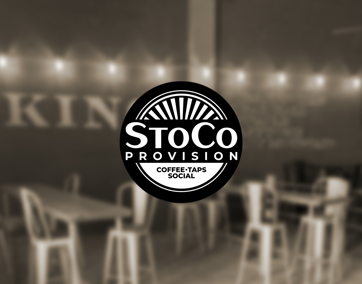 Logo of StoCo Provision with text 'Coffee-Taps-Social' against a blurred interior background featuring string lights and tables with chairs.