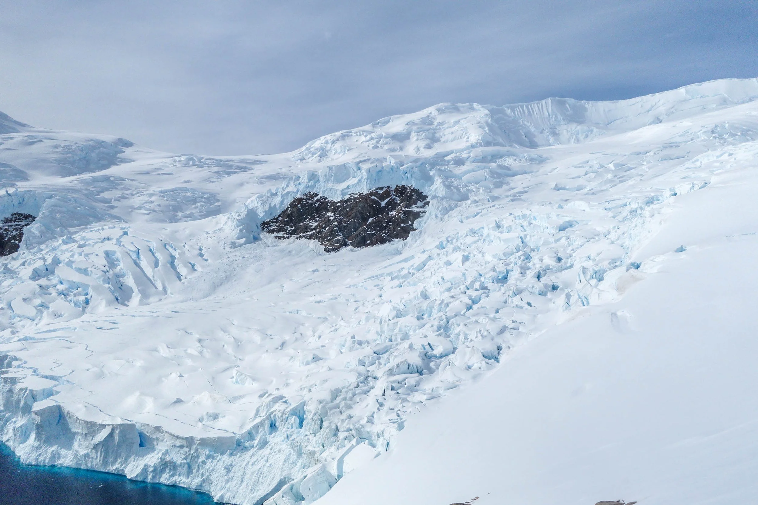 A heart of black rock shaped into the ice of Antarctica