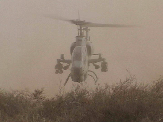 AH-1W Takeoff in dust.png