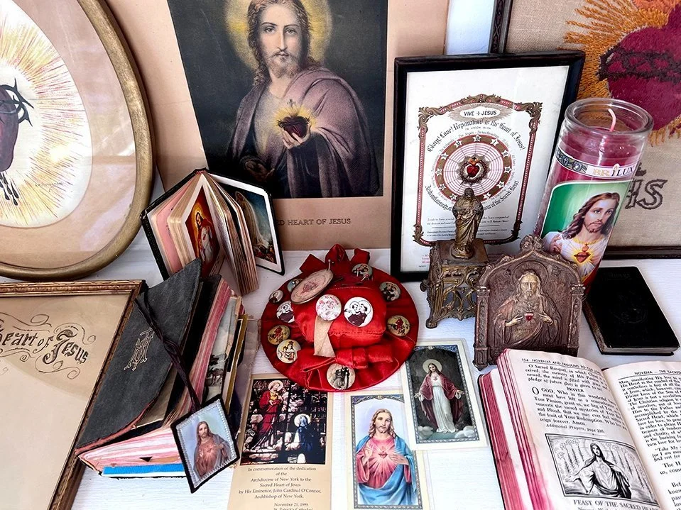 Collection of prayer cards, lithographs, and devotional items featuring images of the Sacred Heart