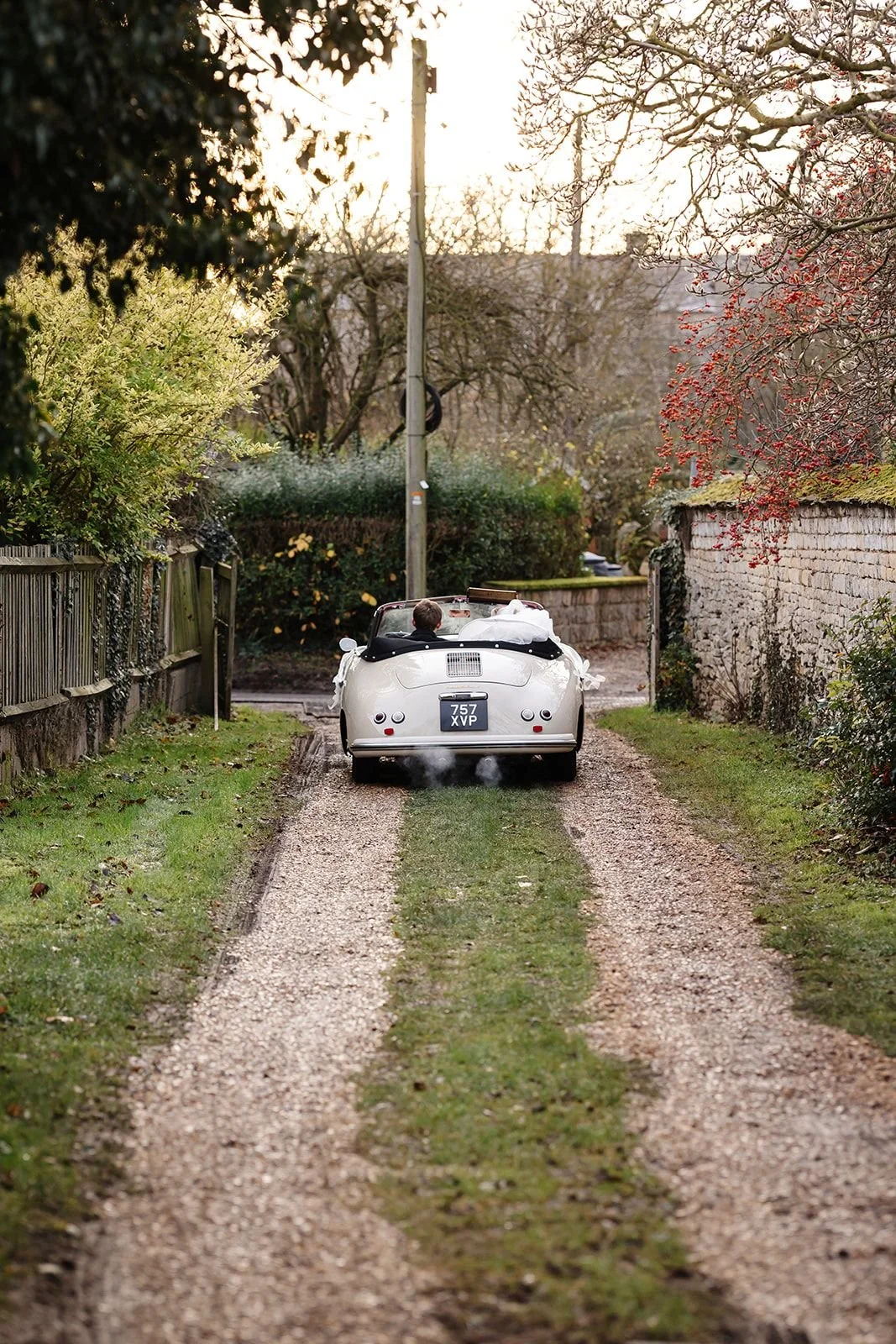 bride and groom driving away in classic porche