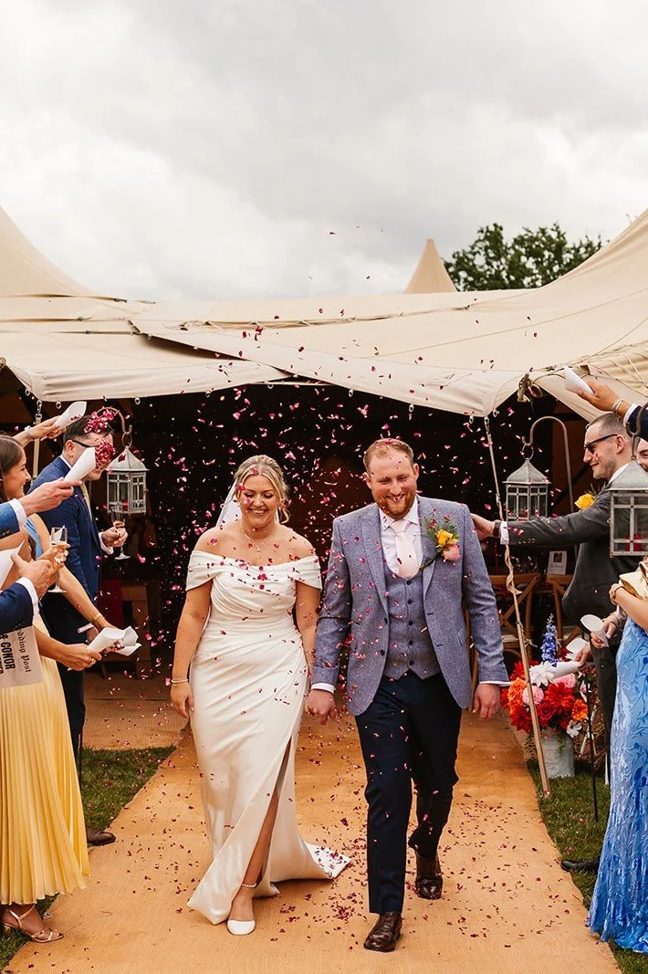 bride and groom walking away from tipi during confetti throw.jpg