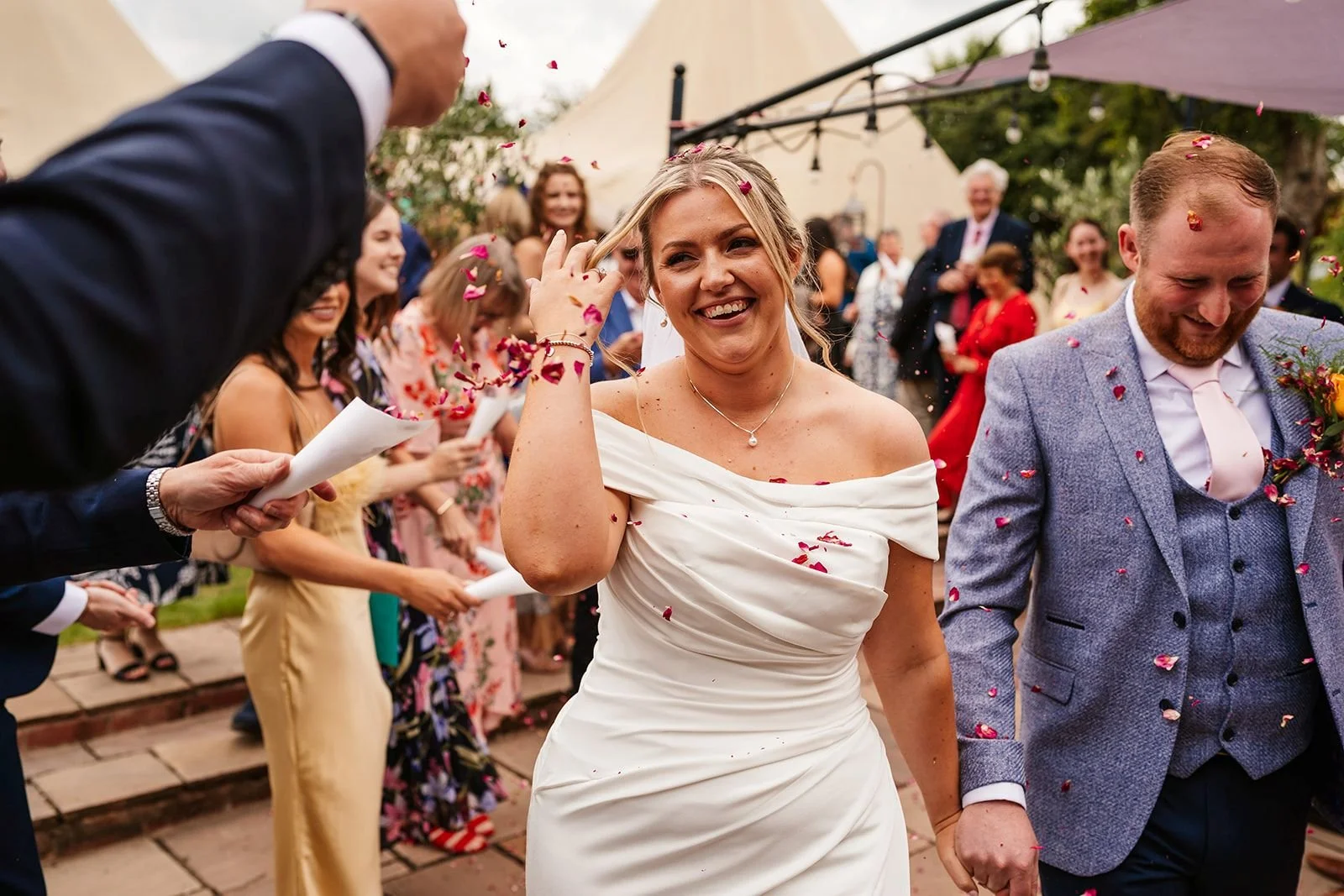 bride and groom walking through confetti shot at tipi wedding