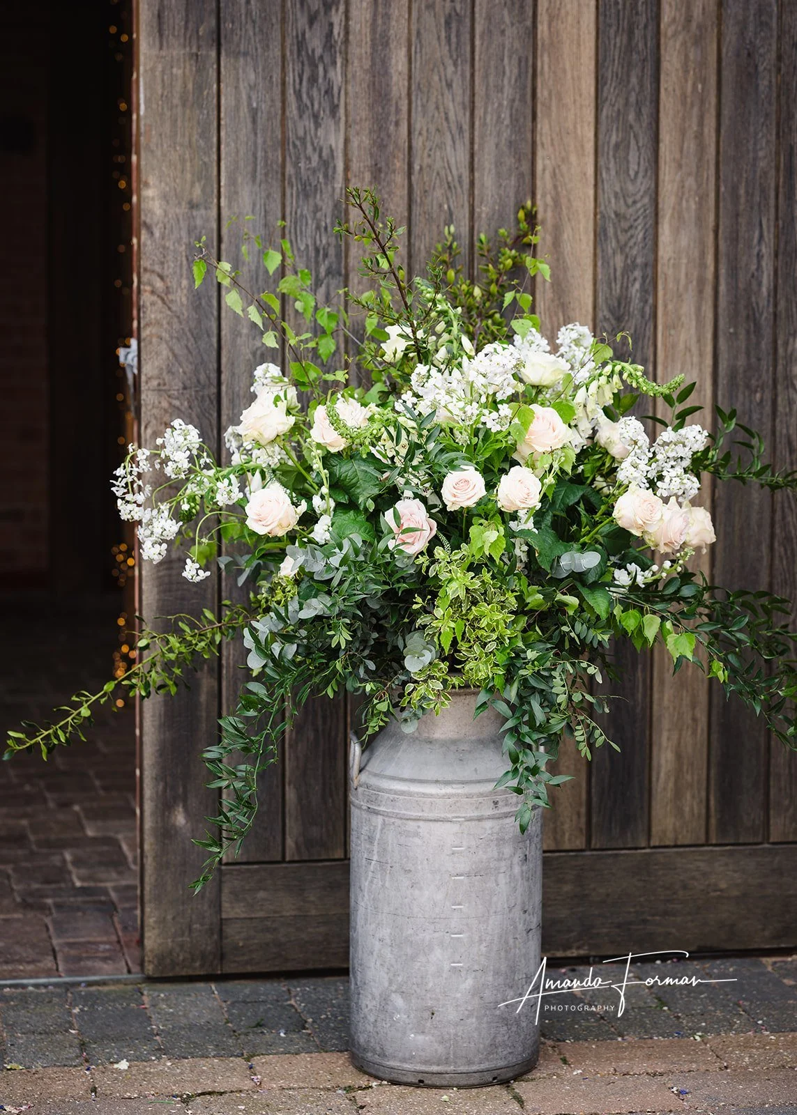 flowers in milk urn outside venue.jpg