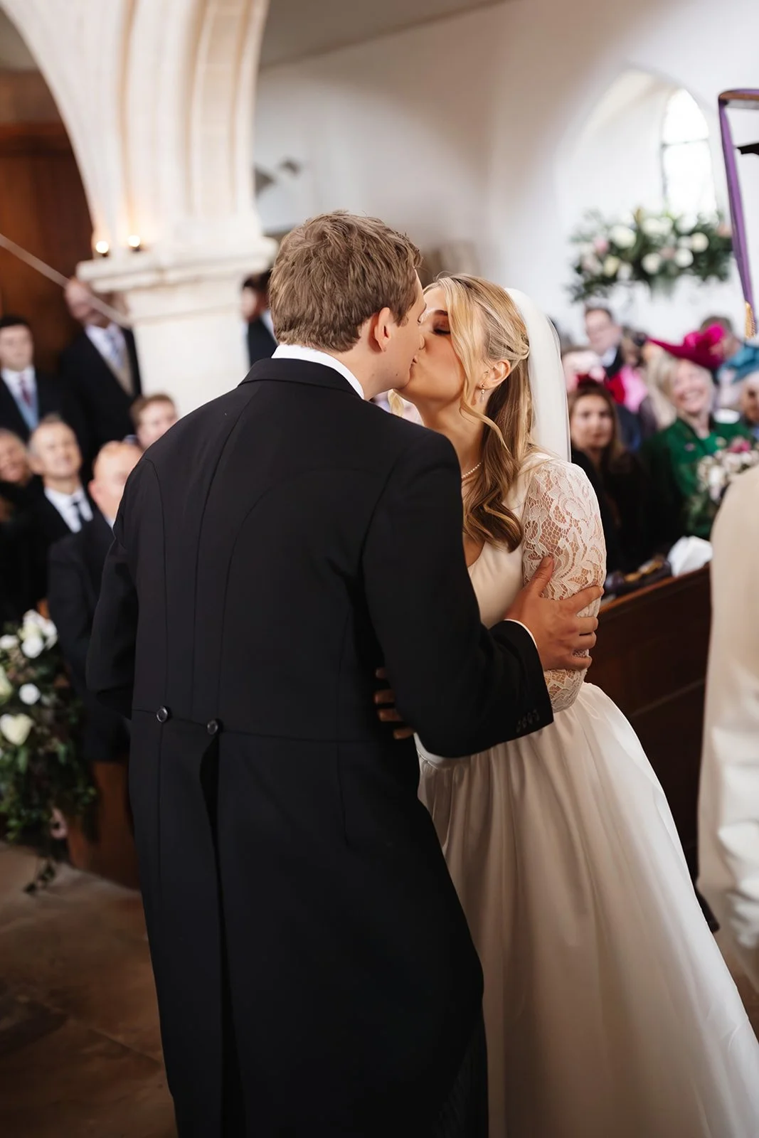 bride and groom share first kiss during church ceremony