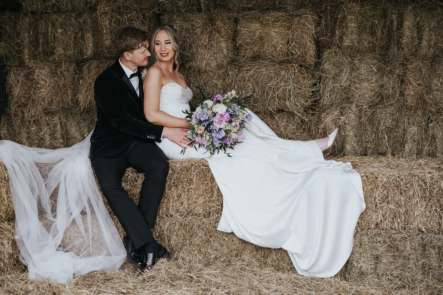 bride and groom on haybales
