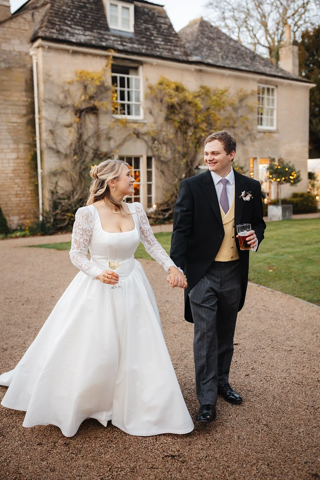 bride and groom walking away from house with champagne
