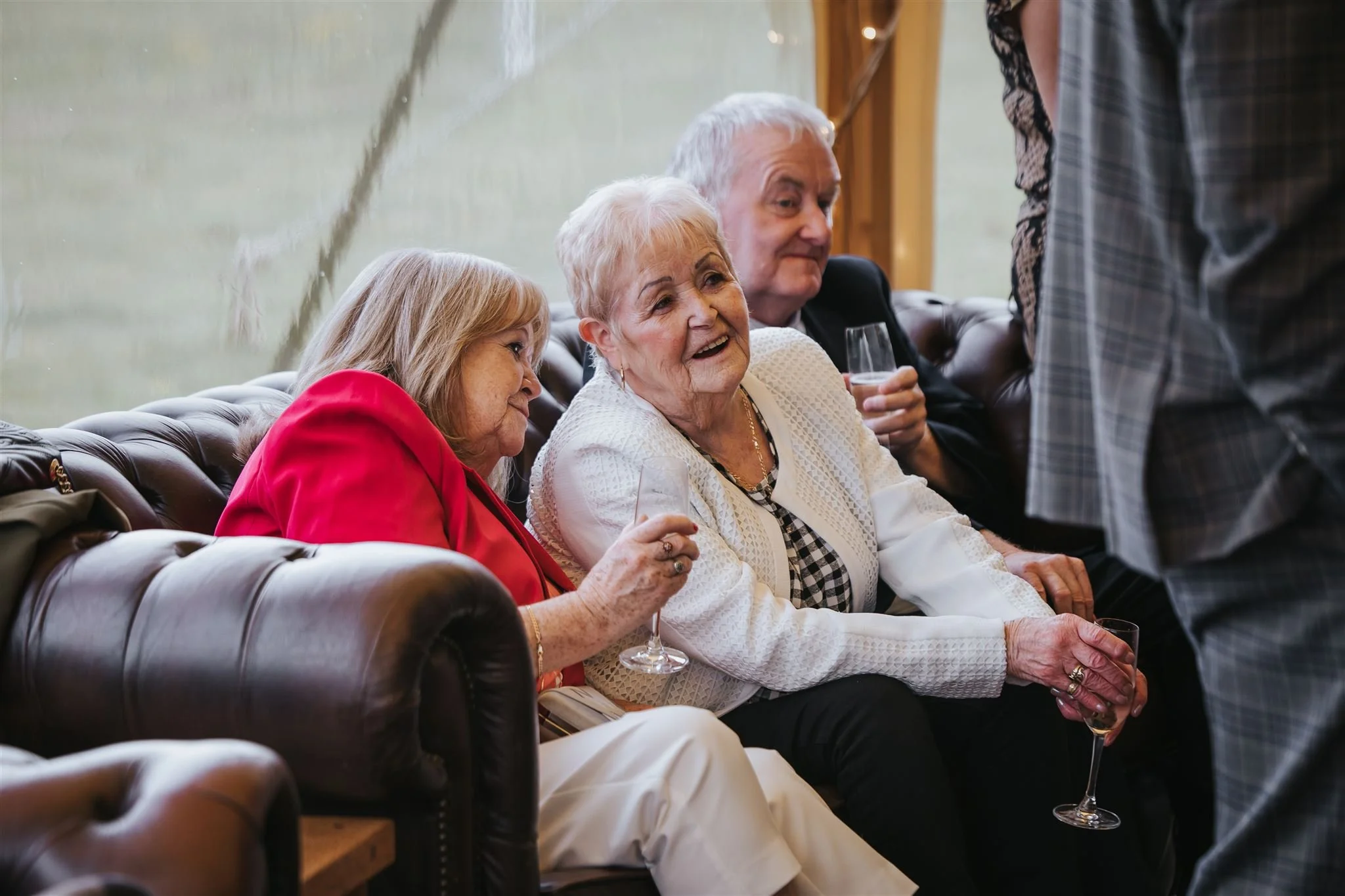 Wedding guests enjoying comfy seating inside marquee