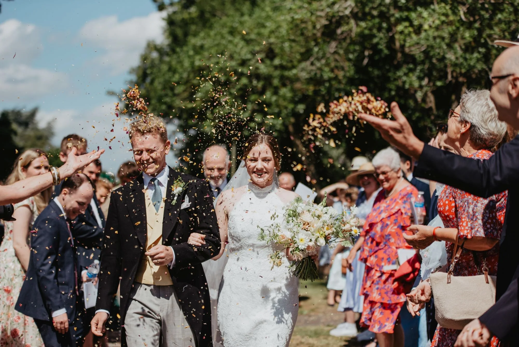 bride and groom after church ceremony walking through confetti throw