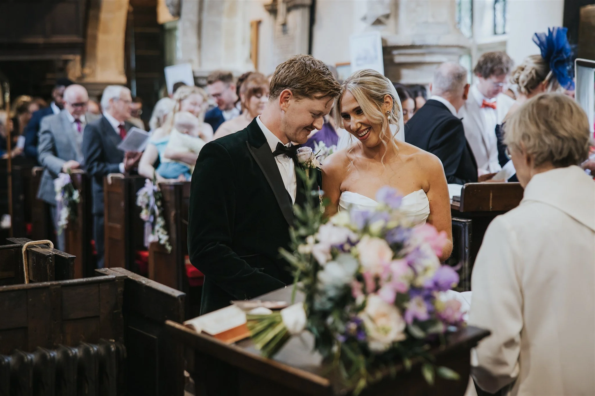 bride and groom during church ceremony with bouquet in front