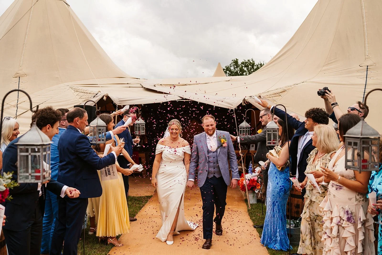 bride and groom walking away from tipi confetti shot