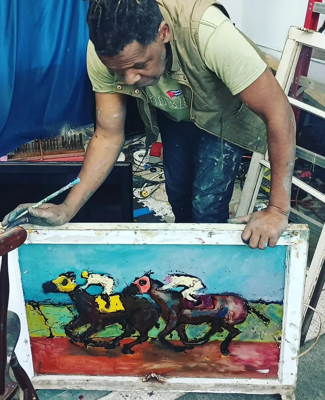Duke holding a painting of horses on a glass window.