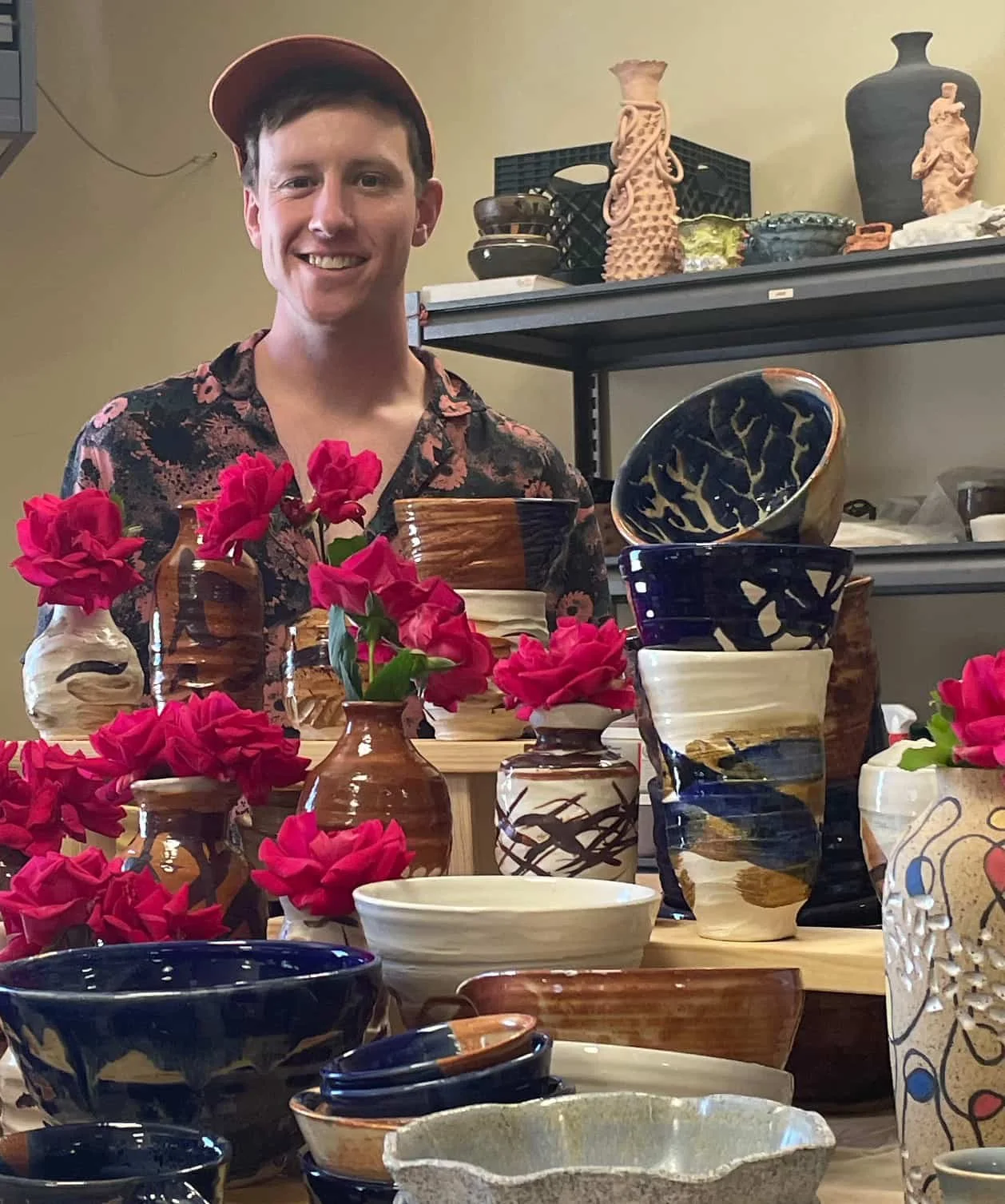 Jared Presnell standing before his ceramics selection at an art show.