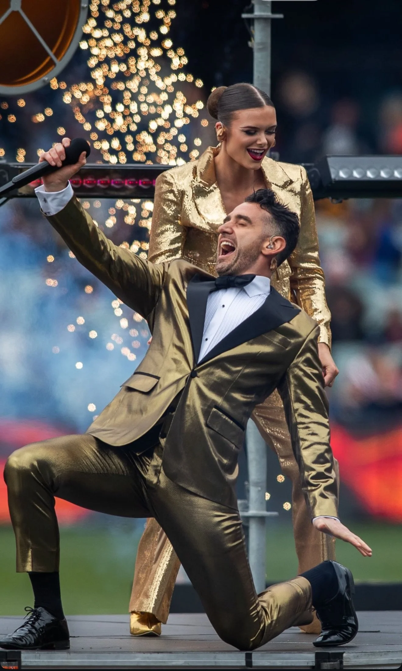 Performers in gold on the field during the pre-match showcase