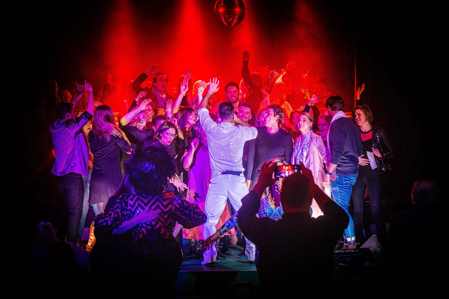 Mike Snell in the middle of a packed dance floor under red stage lights