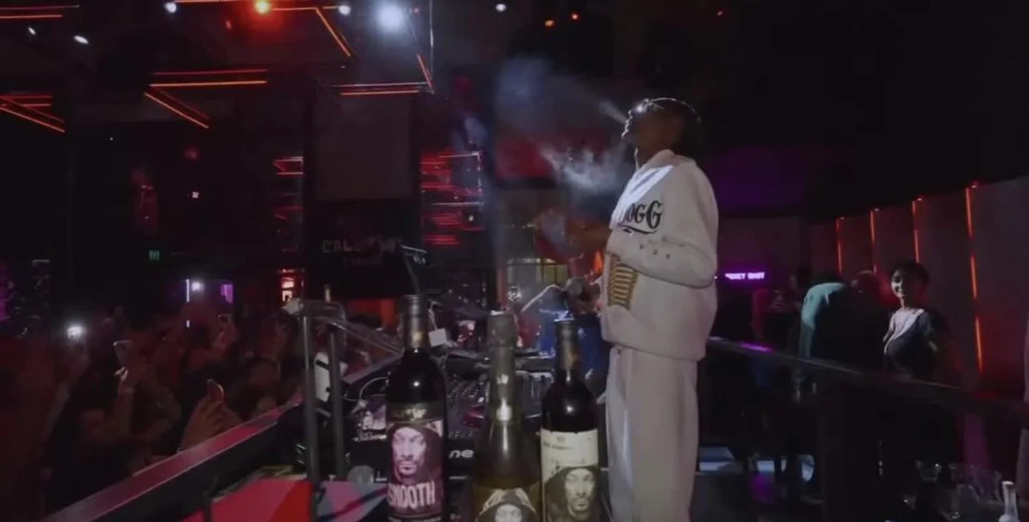 Snoop Dogg performing above the crowd with 19 Crimes wine bottles at the AFL Grand Final after-party