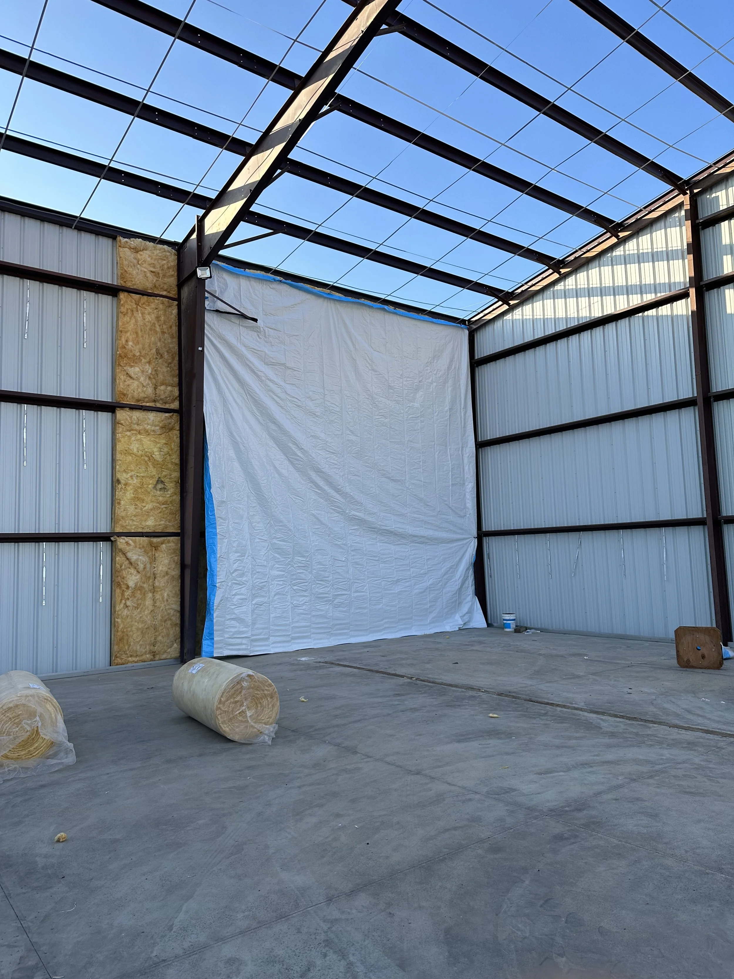 Inside corner of the steel building showing insulated walls for a growing facility. Erected steel building framing showing open roof.