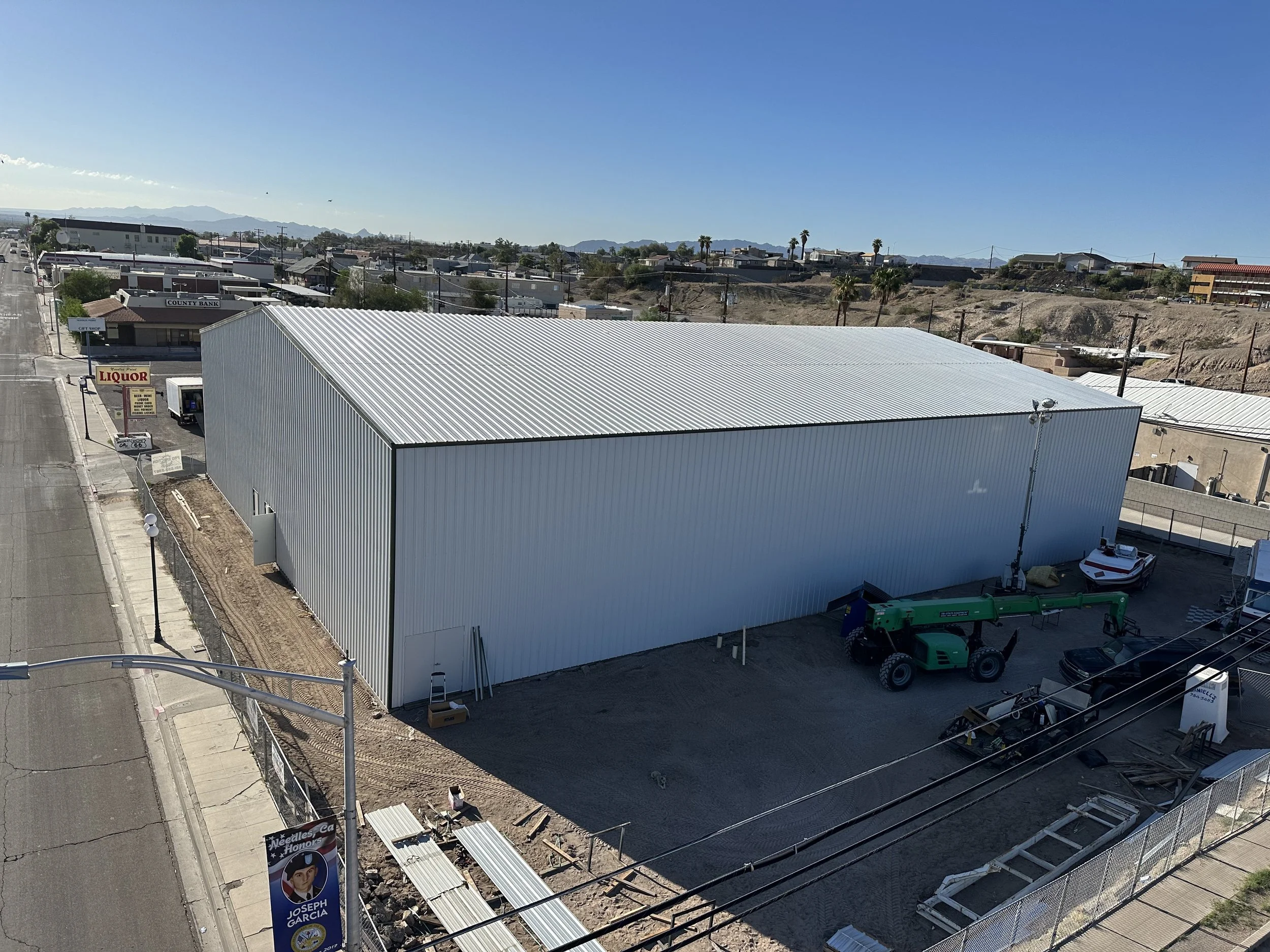 Arial view of completed steel metal building erected by Pro Erection So Cal in Needles California. Crane equipment and white/ red boat parked behind. 