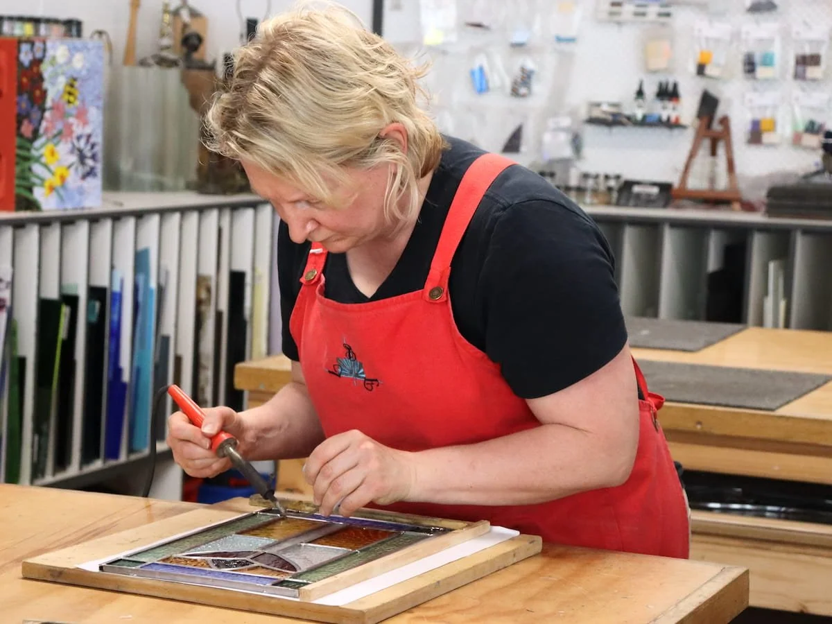 A student soldering a Leadlight Window in the Stained Glass Window Workshop