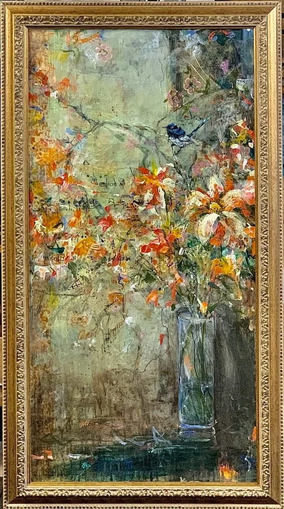 A floral painting in a gold framed canvas, featuring a glass vase with orange, white, and pink flowers, a bluebird perched on a branch, and a textured background with faint sketches and abstract elements.