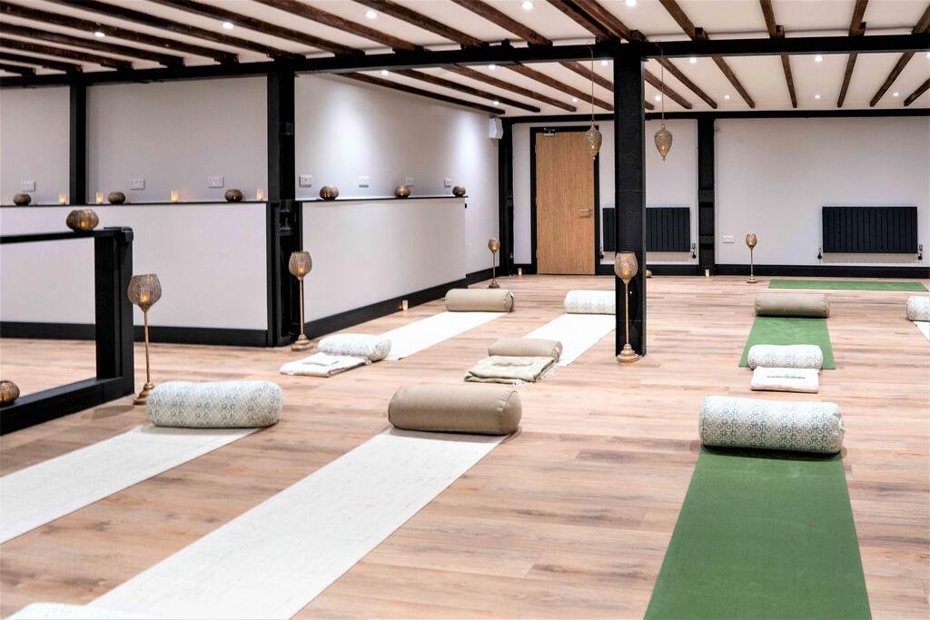 Yoga class studio with mats, bolsters, and candles.