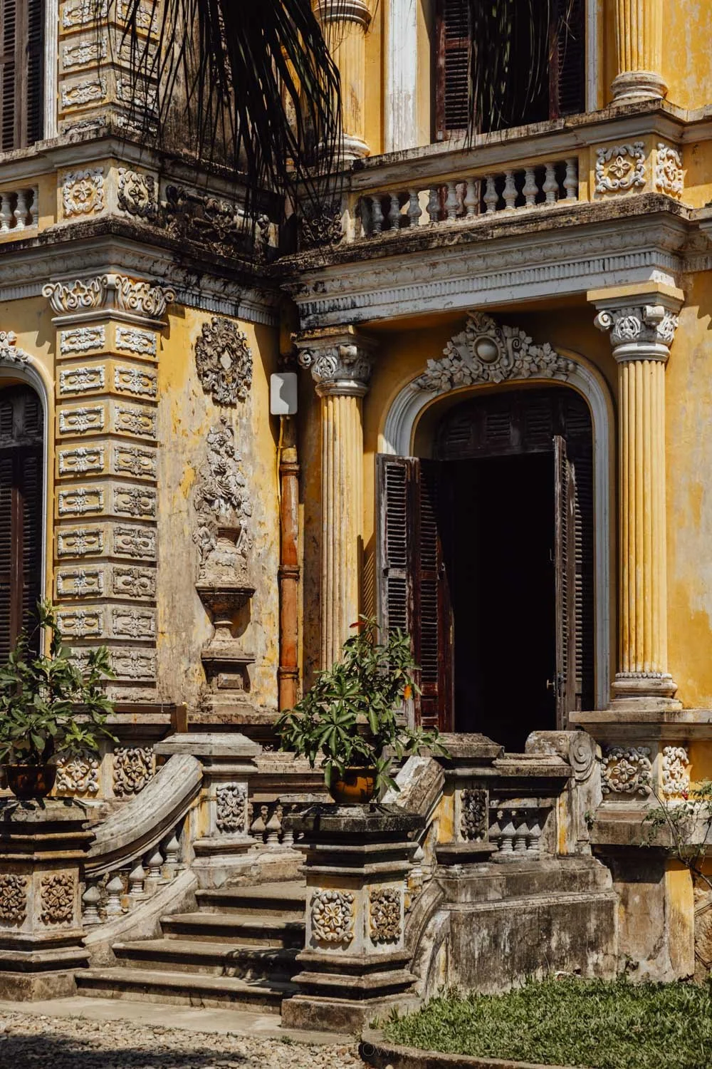 a stone staircase outside a yellow palace exterior at Anh Dinh Palace, Hue, Vietnam