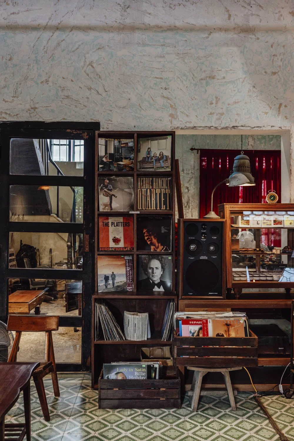 Coffee shop interior with dark wood shelves filled with vinyl records and low lighting