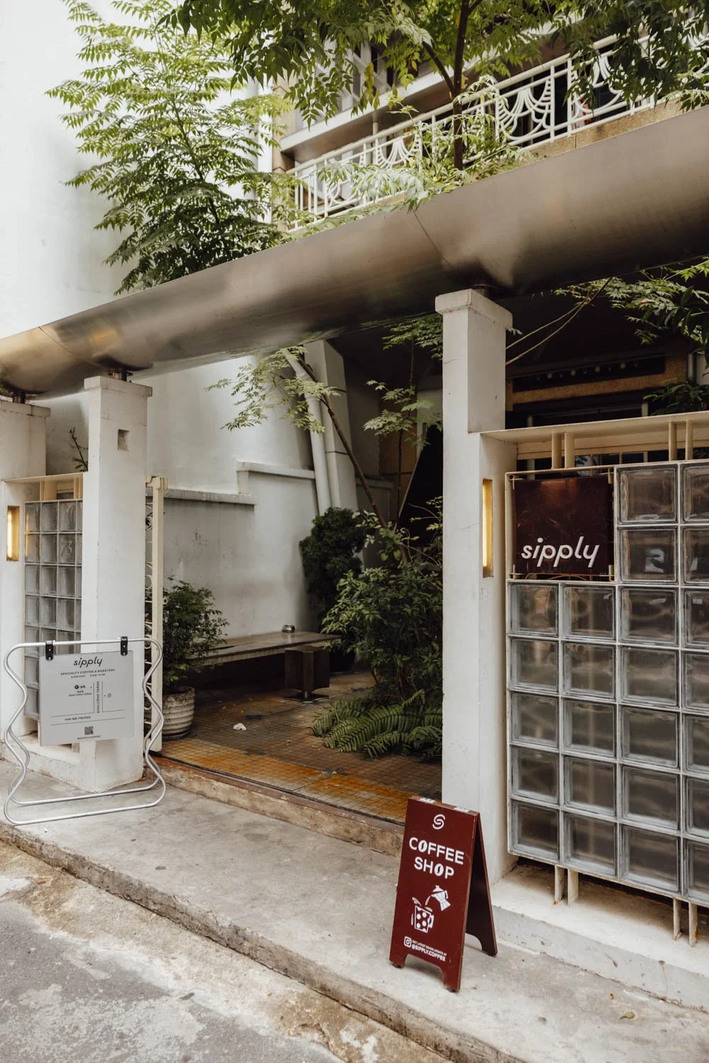 glass brick and leafy exterior of sipply coffee in ho chi minh city, vietnam