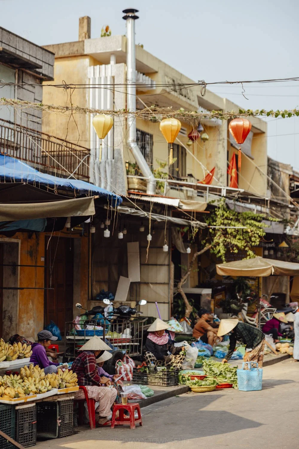 central morning market in hoi an, with fresh fruit and vegetables piled here under tarp canopies