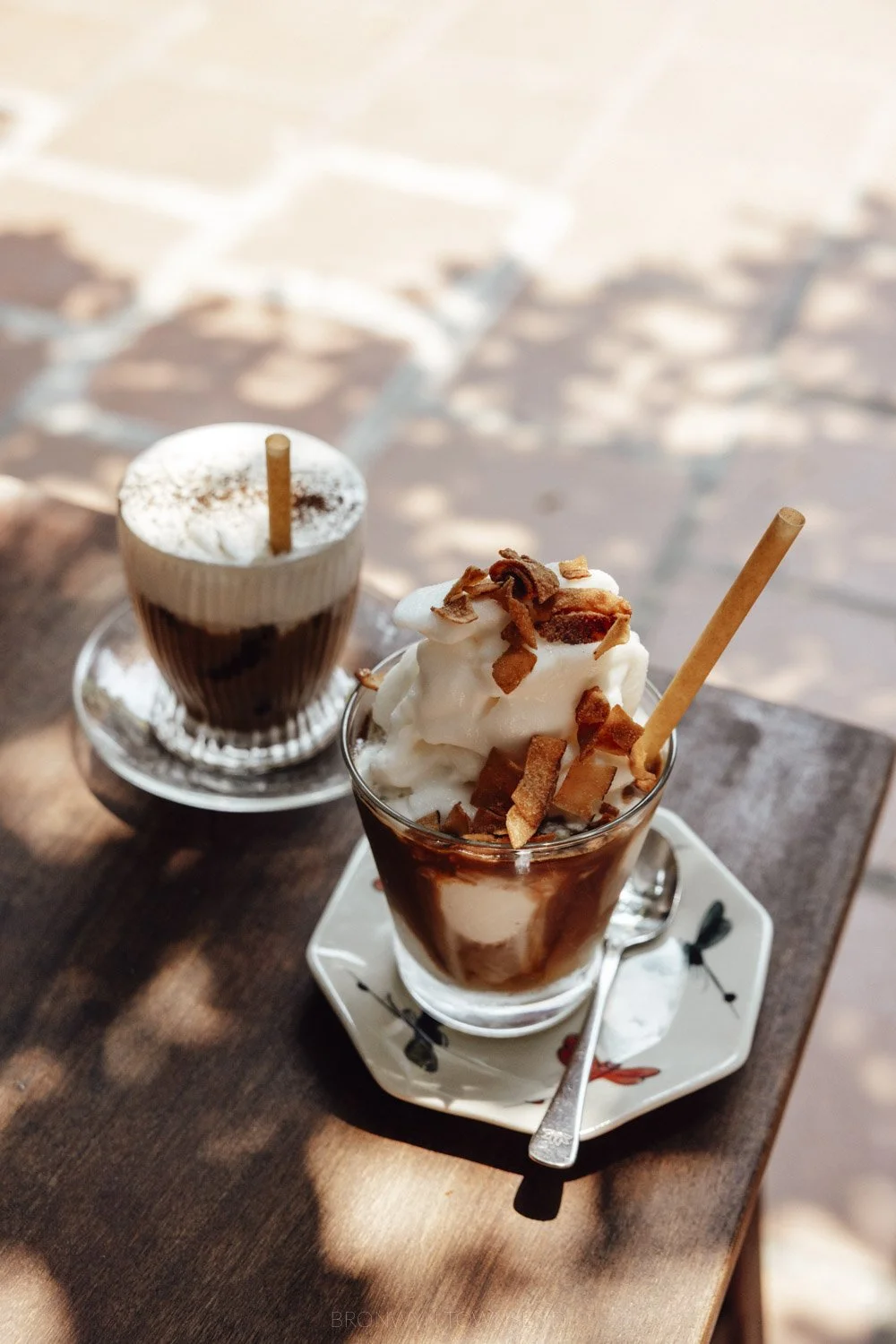 Salt coffee and coconut coffee in glass cups on a wooden table at ren rua cafe in hoi an