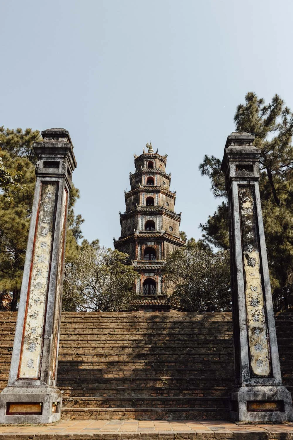 The thien mu pagoda framed between two entry pillars on a sunny day