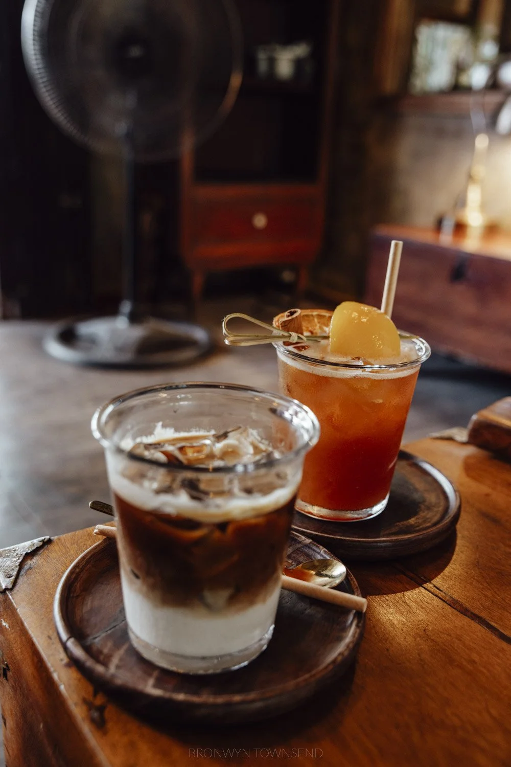 A vietnamese milk coffee and fruit tea on a wooden table