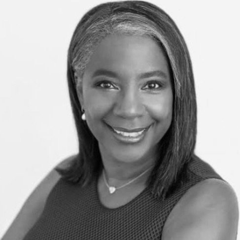 Black woman smiling, wearing a sleeveless top and jewelry, with shoulder-length hair.