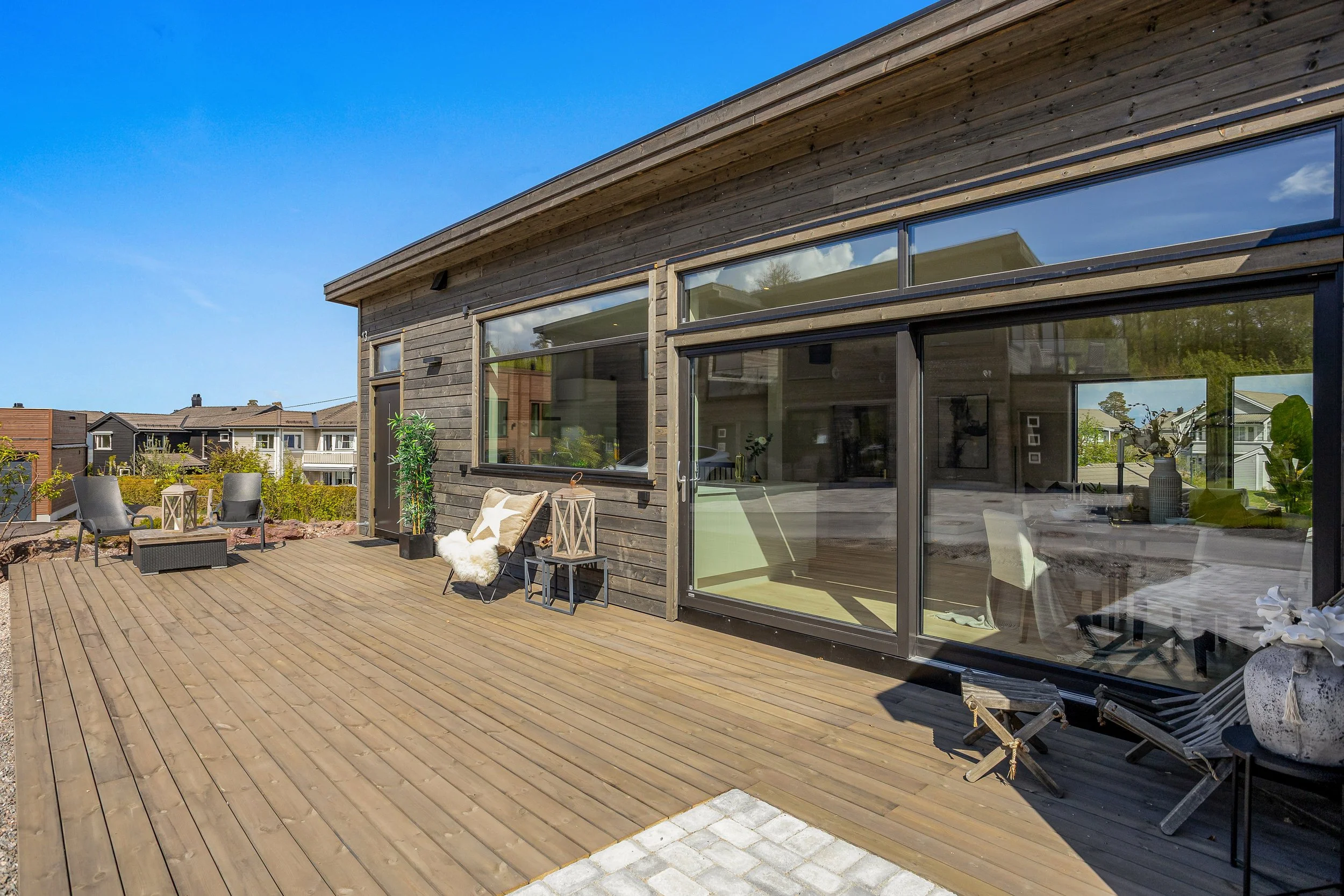 Denne boligen har en stor terrasse med godt plass til lounge, utemøbler og grilling.