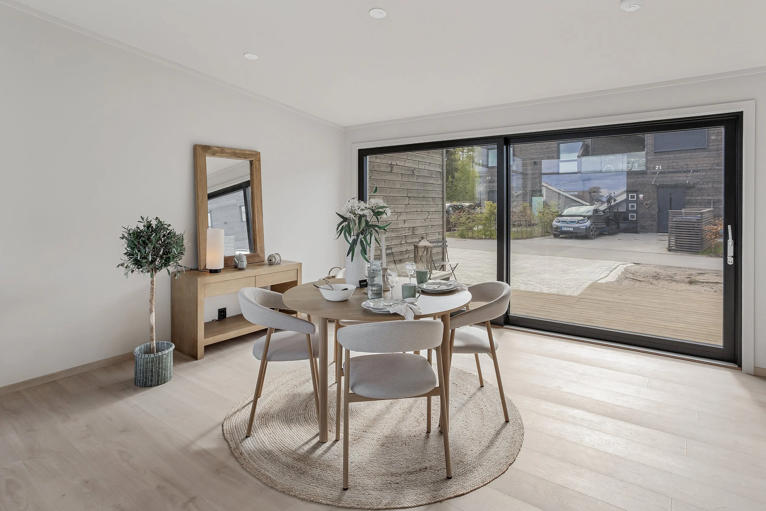 Store skyvedører i glass visker ut skillet mellom inne og ute, og leder ut til terrassen.