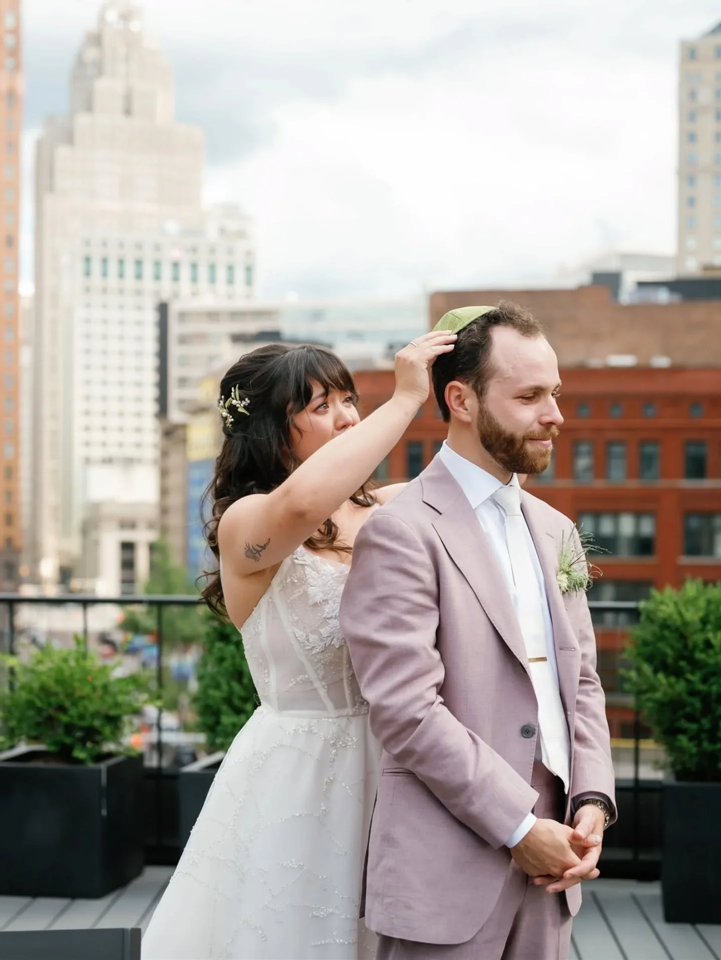On the rooftop of @downtownsynagogue, Stephanie and Charlie shared a quiet moment after signing their ketubah, with the Detroit skyline behind them.

In their own version of the Badeken, Stephanie placed Charlie&rsquo;s kippah on his head before the 