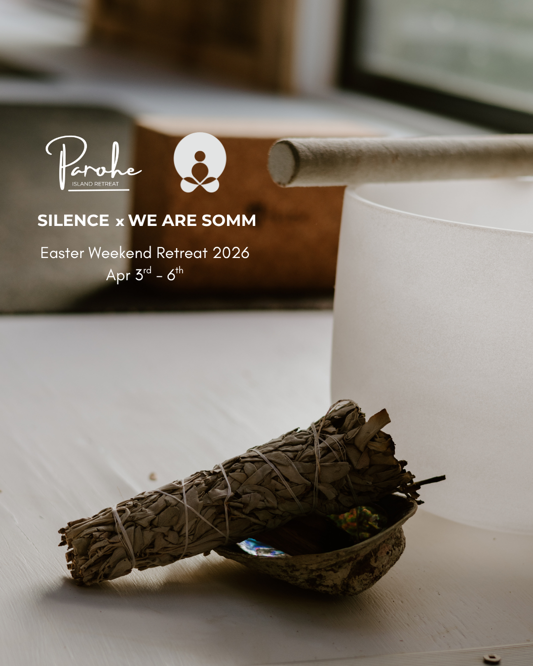 Close-up of a bundle of sage smudge sticks resting on a small decorative bowl, with a white container and a window in the background.