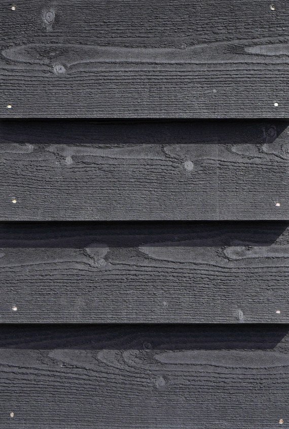 Close-up of dark stained wooden horizontal planks on a wall.