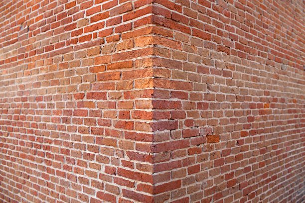 Brick wall corner with red and brown bricks.
