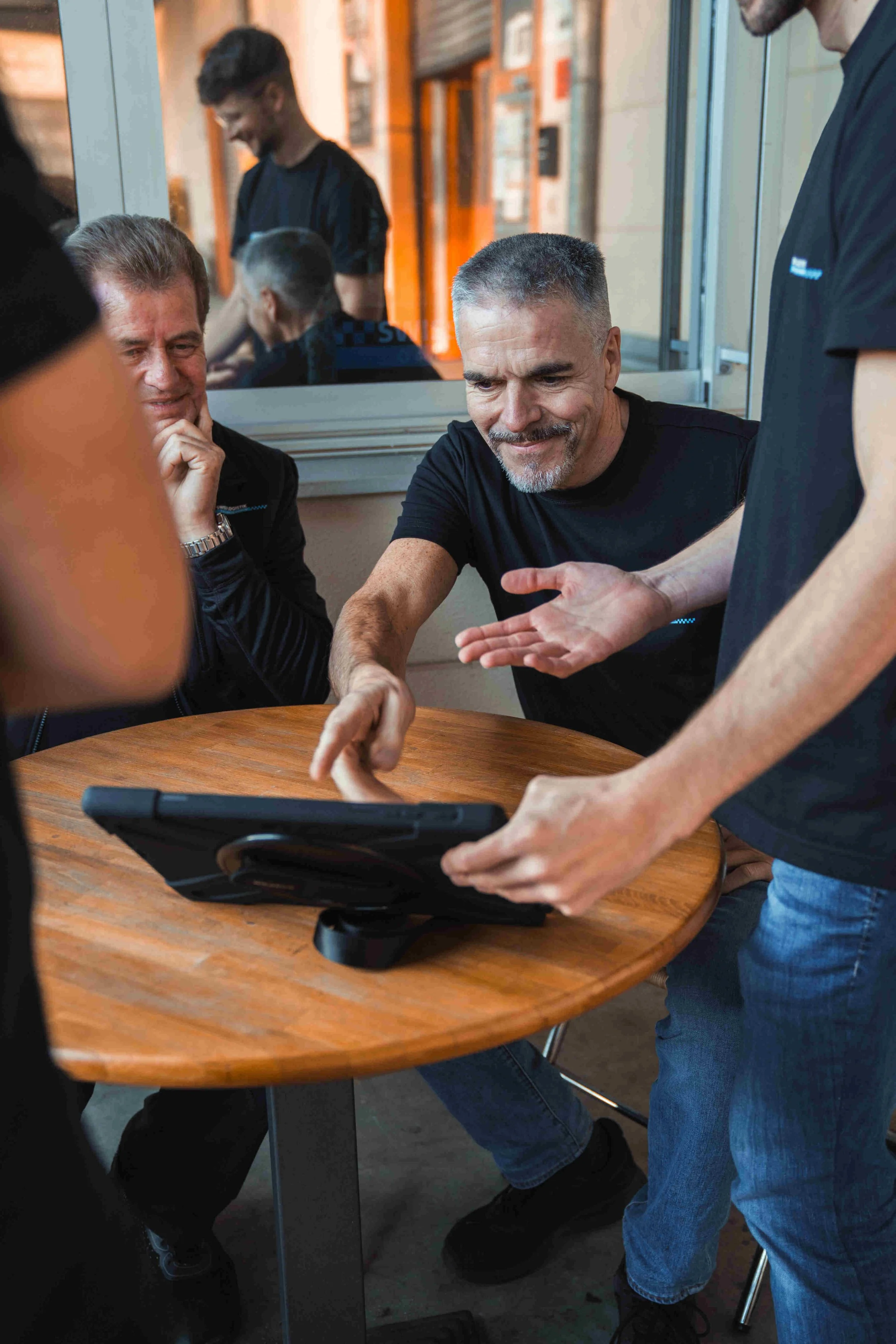 Mitarbeiter mit einem Tablet bei einer Teambesprechung