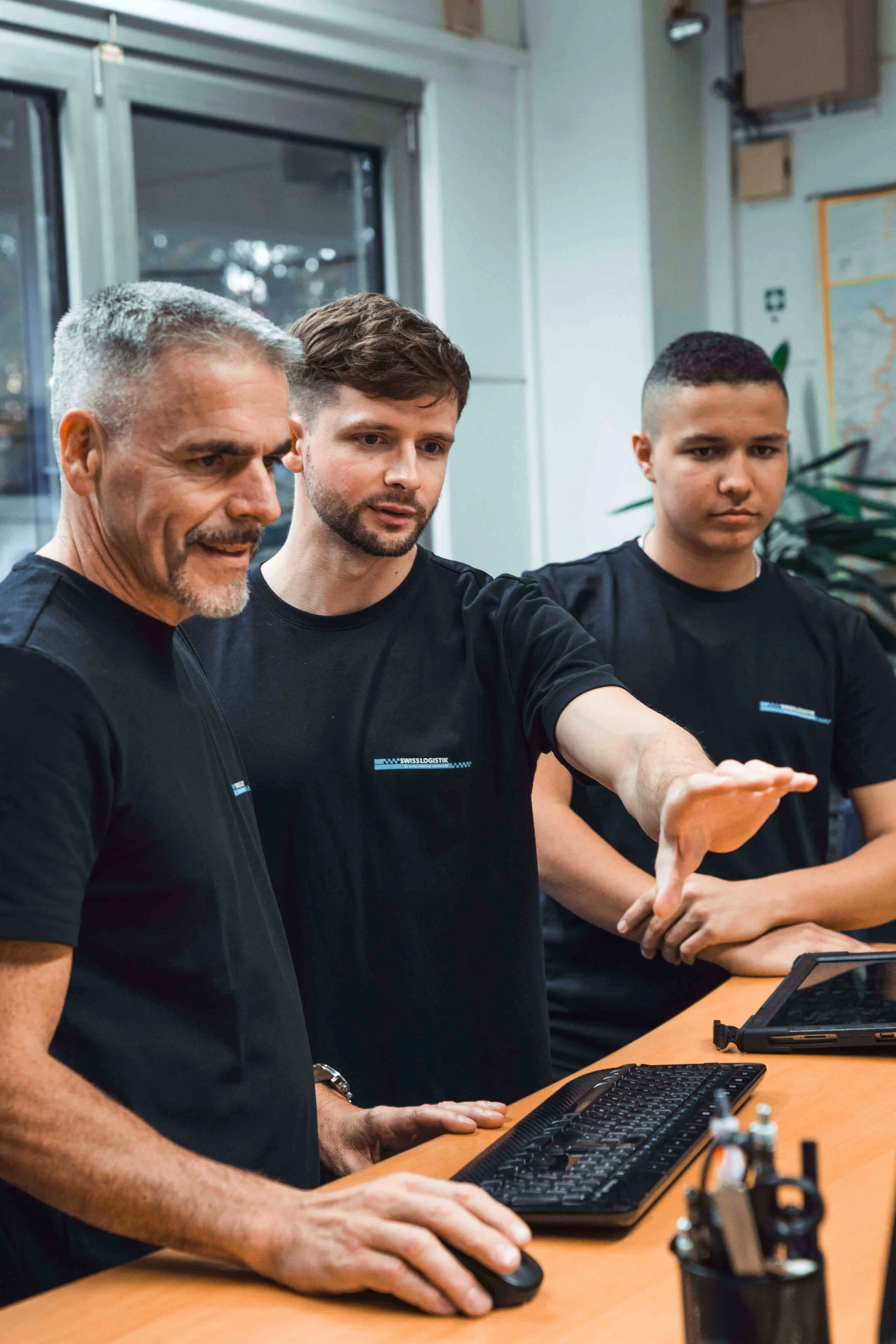 Drei Mitarbeiter vor einem Computer