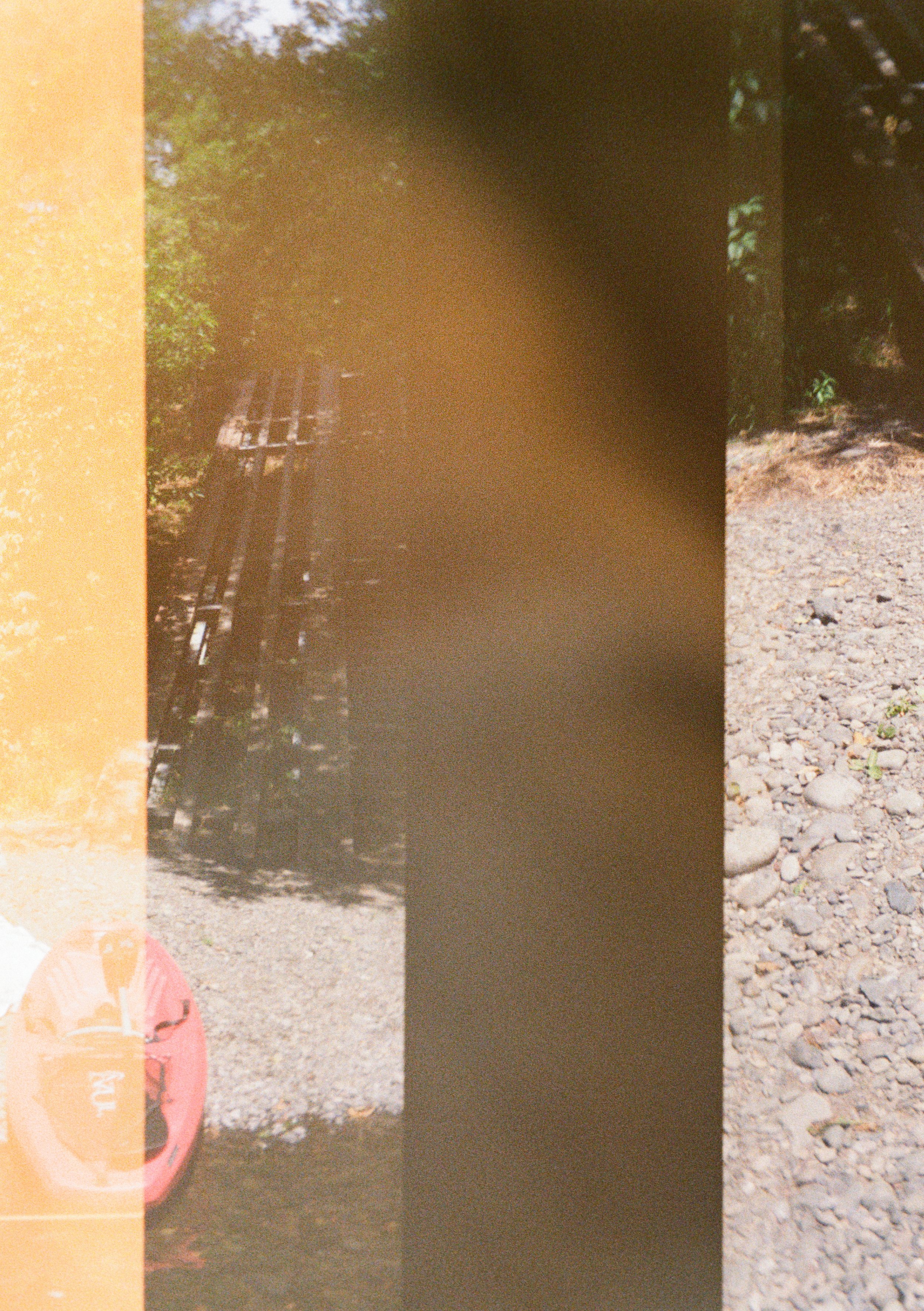 Photos of outdoor scene with trees, rocky ground, and a pink kayak, partially obscured by a vertical streak and a shadow.