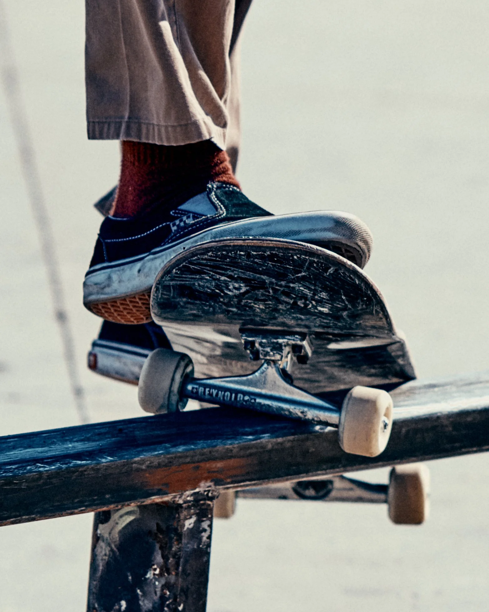 Skateboarder balancing on a skateboard on a rail at skate park.