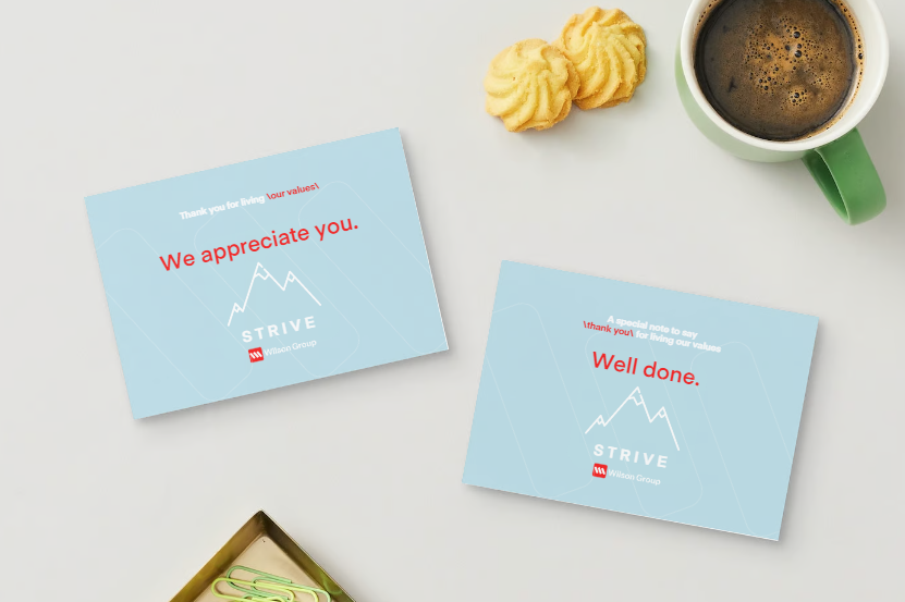 Two thank you cards, a cup of coffee, two cookies, and a green pen on a white surface.