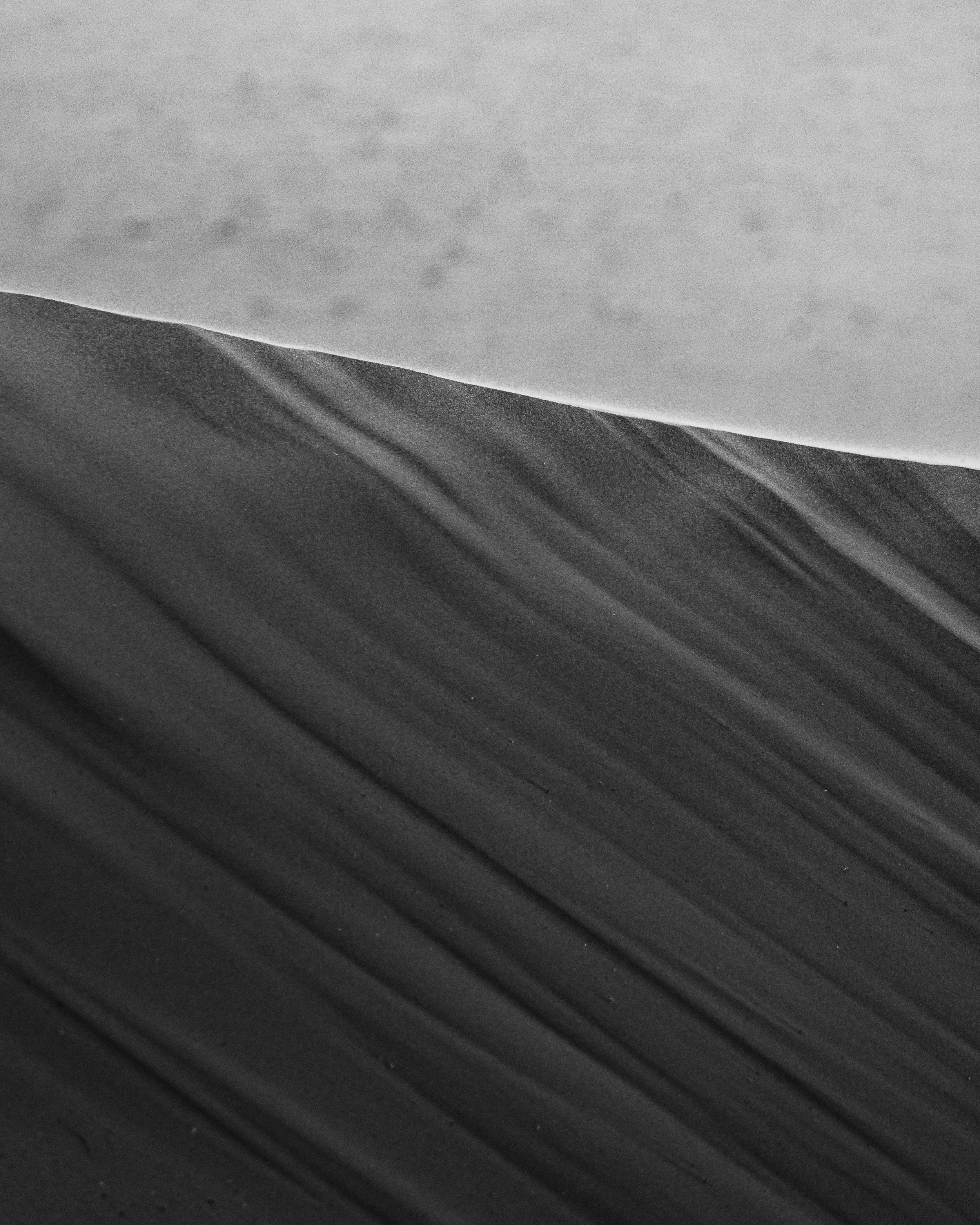 Close-up of textured black and gray paper or material with diagonal lines.