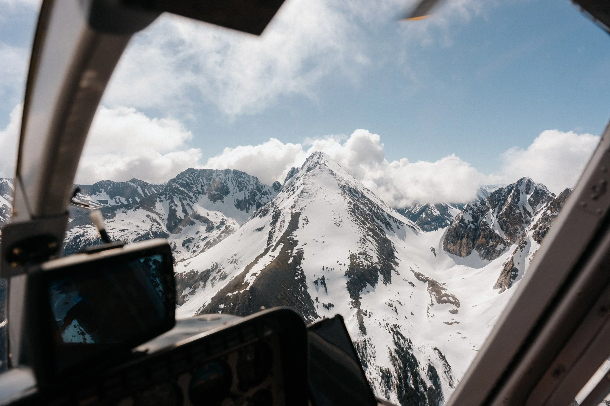 Snow-capped mountains seen from inside an aircraft fuselage.