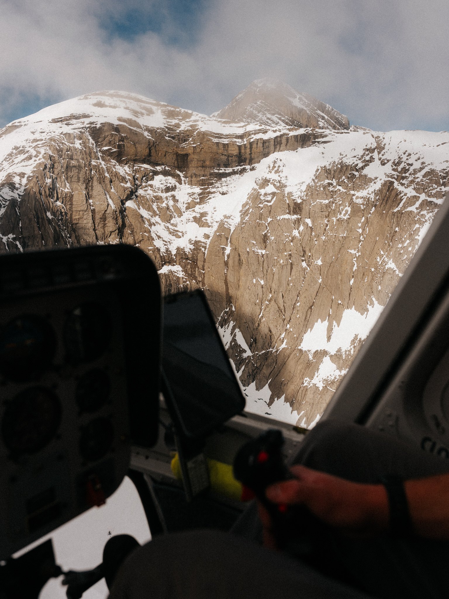 Snow-capped mountain peaks viewed from an aircraft window.