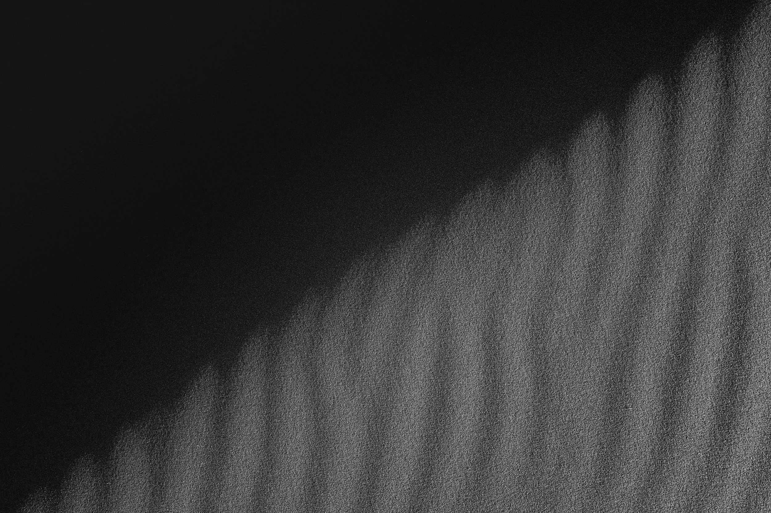 Close-up of a textured black and gray surface with diagonal pattern.