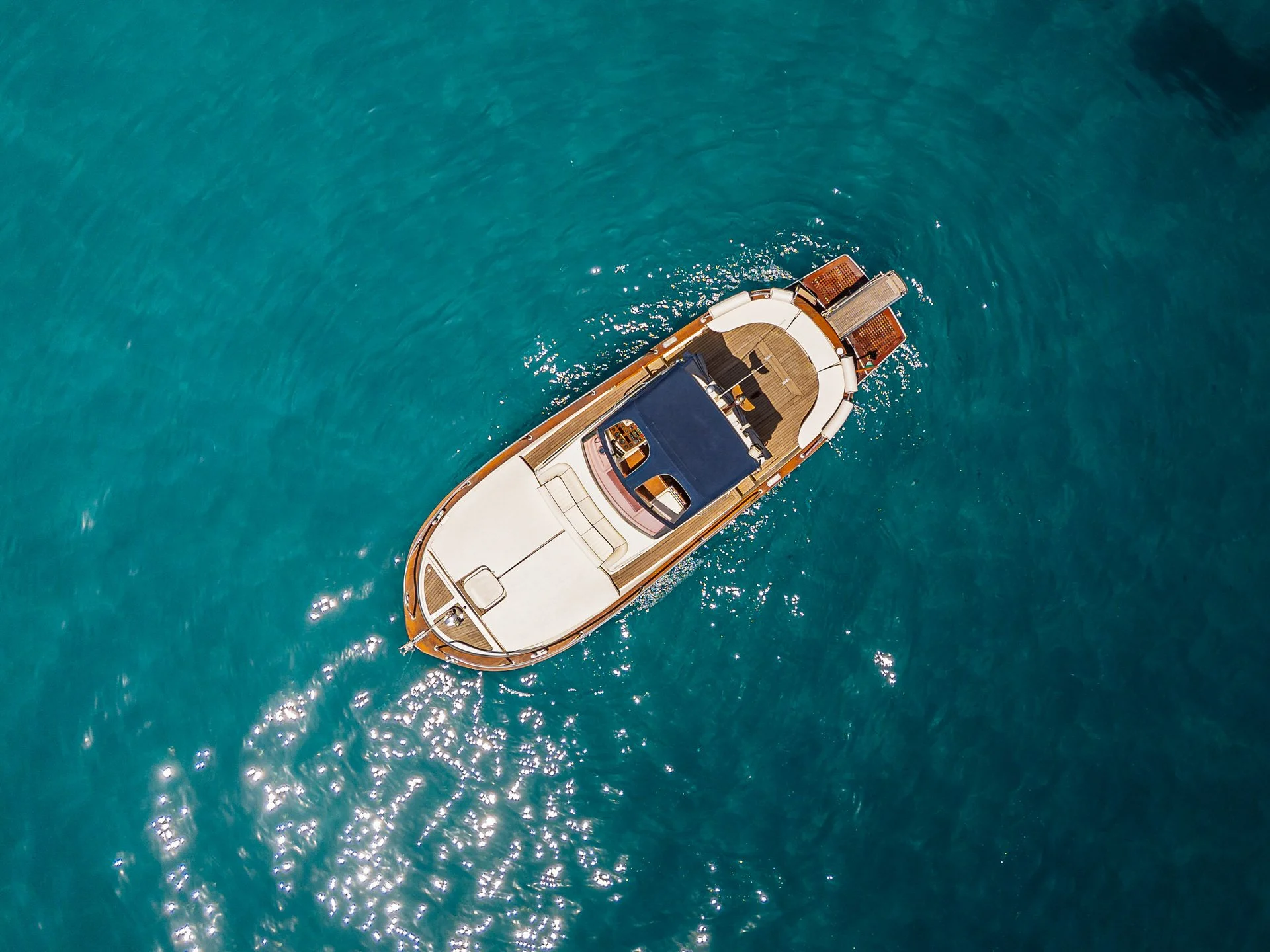 Aerial view of a yacht floating on clear blue water