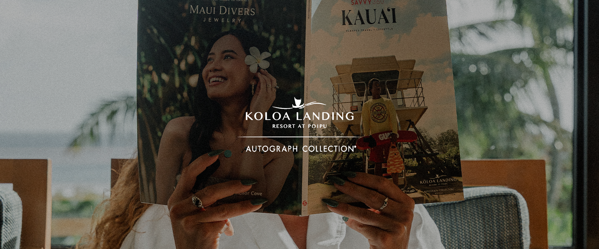 A person holding two brochures about Kolua Landing Resort at Poipu, with tropical scenery visible through a window in the background.